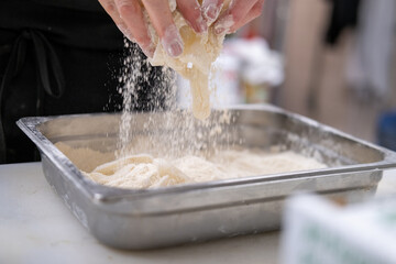 Calamari being coated in flour