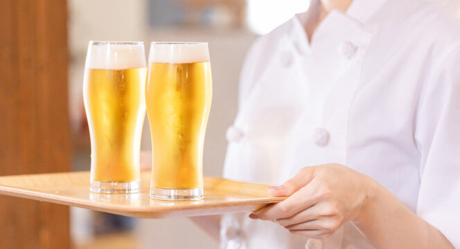グラスの生ビールを持つ女性シェフ・調理師（アルコール・お酒）