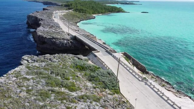 Cinematic aerial view drone shot flying over glass window bridge on the island of eleuthera in the bahamas - separating the atlantic ocean from the caribbean sea