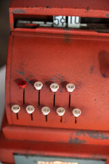 Vintage red cash register with white push buttons