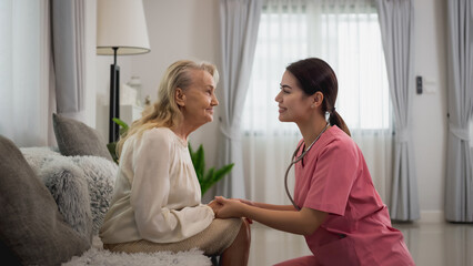 Young professional confident skilled woman doctor visiting old patient lady at home for treatment control care giving. Nurse talking to Caucasian senior patient. Healthcare concept