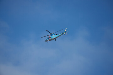 Fototapeta na wymiar 青空に飛んでいるヘリコプターの様子