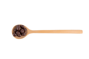 Chocolate balls on wooden spoon on white background.