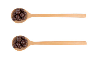 Chocolate balls on wooden spoon on white background.