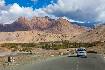 Rural road in north India with a mountain backdrop in winter. High mountains and cedar forests...