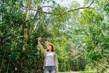 tired woman carrying a backpack travel and walking in the forest. cheering asia woman open arms at mountain peak