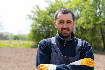 a man planting potatoes in the ground in early spring. Farmer with a shovel