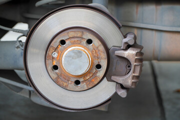 Car brake disc for garage repair
, in process of new tire replacement. Car brake repairing in garage.Suspension of car for maintenance brakes and shock absorber systems.Close up.