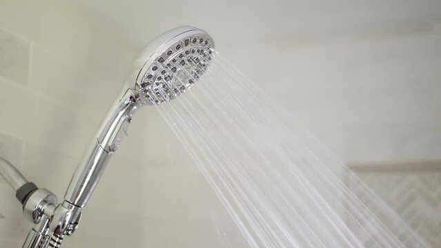 Chrome shower head in the bathroom is hard on. Close up shot