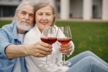 Senior couple holding two glasses with wine in front of themself