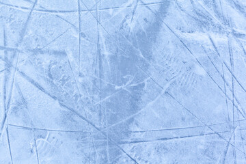 Empty ice rink with skate marks after the session outdoor. skating ice rink texture covered with snow in daylight. Close up of blue ice rink floor, copy space
