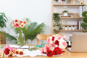 Florist concept, Colorful gerbera in vase and flowers in paper bag with equipment at flower shop