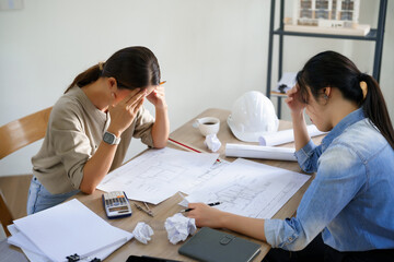 Obraz premium Concept of engineering consulting, Two engineers stressful while sketching blueprint of new project