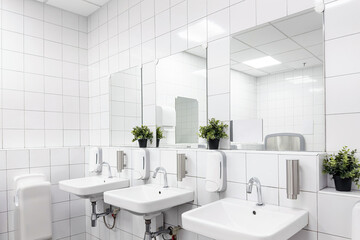 Toilet hand wash area with white colour ceramic tiles. White colour theme toilet interior....