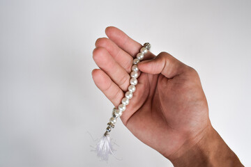 Religious muslim man praying with rosary beads isolated on white background