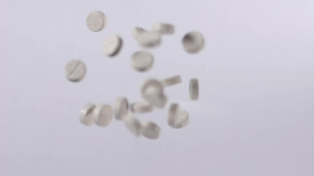 Slow Motion Shot Of Grey Supplements Medical Pills Flying In Air