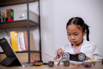 Asian students learn at home by coding robot cars and electronic board cables in STEM, STEAM, mathematics engineering science technology computer code in robotics for kids' concepts.