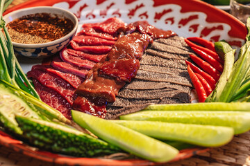Traditional food in Thailand, Thai local food menu with raw food ingredient in the local name of Soi Ju, Sajin, Laab, koy, Soy Ju, raw meat with chili spicy sauce over dish on table background