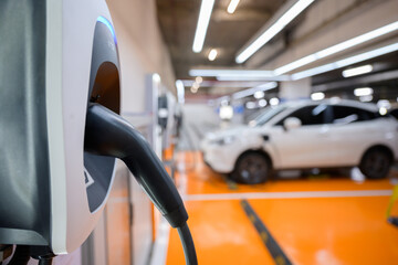 Close-up of an electric car charger Electric vehicle charging station covered with epoxy floor Car park for electric cars to recharge green energy to reduce CO2 emissions.