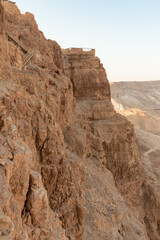 The remains  of outer walls in the rays of the rising sun in the ruins of the fortress of Masada -...