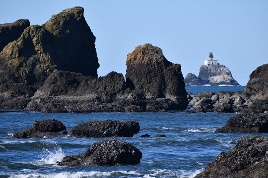 Dangerous rocky formations with lighthouse in the background.