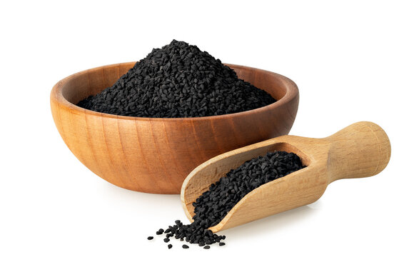 black cumin seeds in wooden bowl and scoop isolated on white