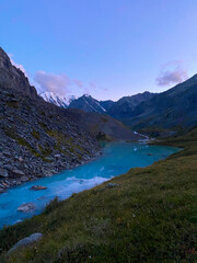 Mountain lake calm turquoise with clear water Karakabak in the Altai mountains with snow and glaciers in the evening at sunset. Vertical frame.