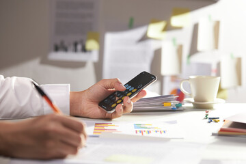 modern office desk at morning. businessman calculates the balance. closeup