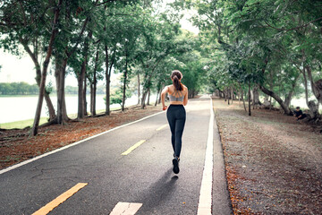 Healthy woman runner running in the park in the morning. Healthy lifestyle concept