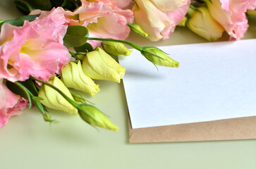 A branch of eustoma flower and a letter lies on the table