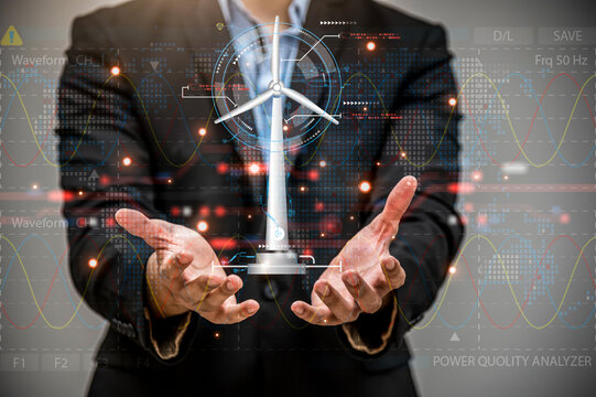 Businessman hand holding glowing digital wind mill turbine hologram, Wind generator and clean energy concept.