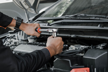 Naklejka premium Mechanic fixing a car at home. Repair and service.