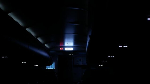 view to the exit sign for exit emergengy door while light on prepare for landing in night time, inside cabin airplane safety