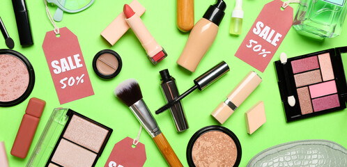 Fototapeta na wymiar Cosmetic products with sale tags on green background