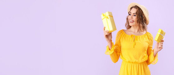 Happy young woman with gifts on lilac background with space for text