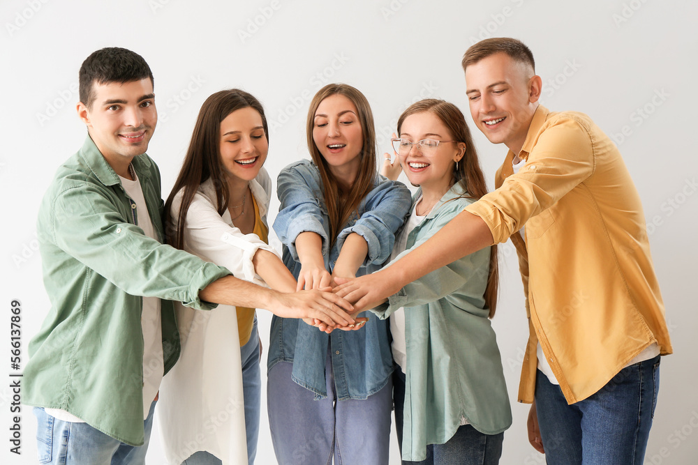 Sticker Group of happy friends putting hands together on light background