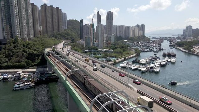 Train and cars on the bridge in Hong Kong. Aerial drone view. Harbour view with boats and yachts. Aberdeen and South Horizons. Hong Kong is a centre of finance business in China, Asia.
