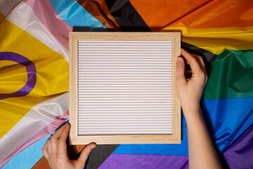 Empty blank frame on Rainbow LGBTQIA flag made from silk material with copy space for your text....