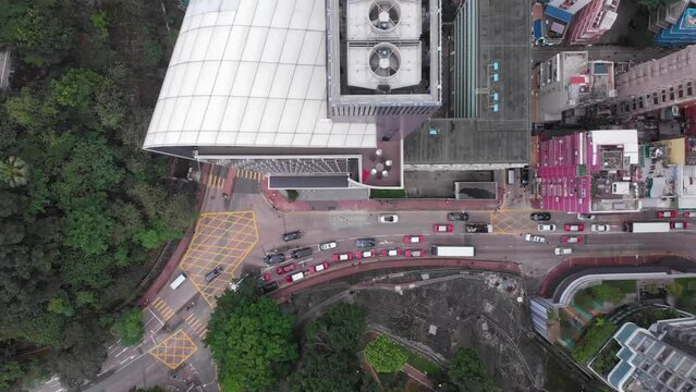 Aerial drone view of the building with fans on the rooftop. Traffic down below. Hong Kong Island. Asia
