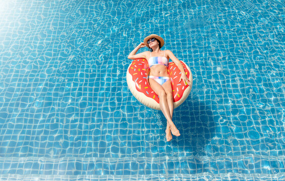 Beautiful Woman With Inflatable Donut In Pool