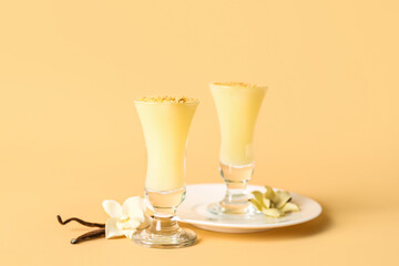 Plate with shots of delicious vanilla pudding on beige background
