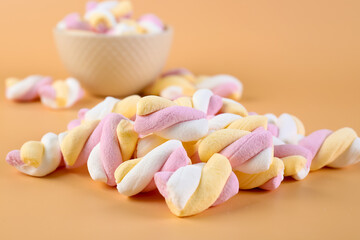 Heap of tasty twisted marshmallows on beige background