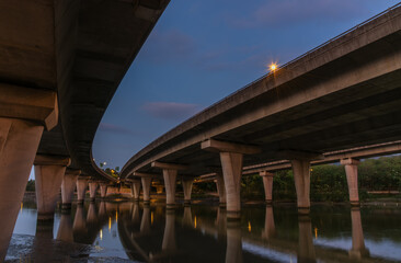 Obraz premium Underside of an elevated road across river at dusk