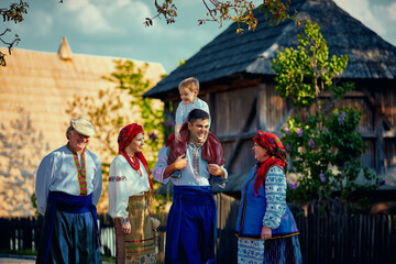 Fototapeta na wymiar happy ukrainian family in traditional costumes walking down an old village street