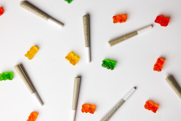 Top view of some colorful gummy bears and some cannabis joints