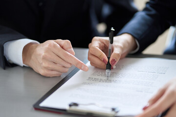 契約内容を確認するアジア人ビジネスパーソン