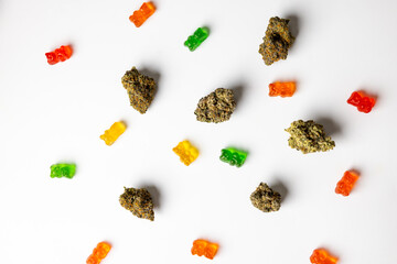 Top view of some gummy bears and some cannabis dried nugs