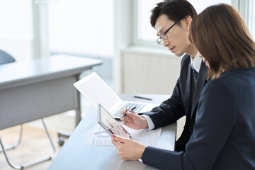 タブレットで打ち合わせをするアジア人ビジネスパーソン