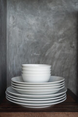 Clean and white dishes in a cabinet 