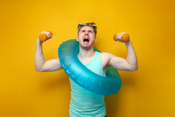 guy with an inflatable swim ring in the summer on vacation raises small dumbbells and shouts on a...